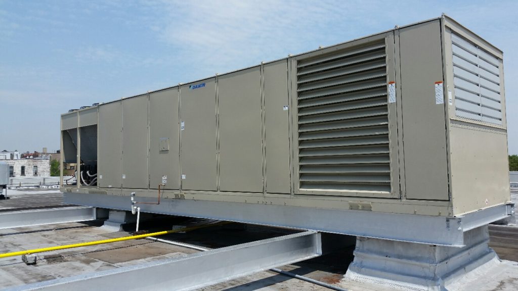 a man pressure washing outside of industrial hvac system