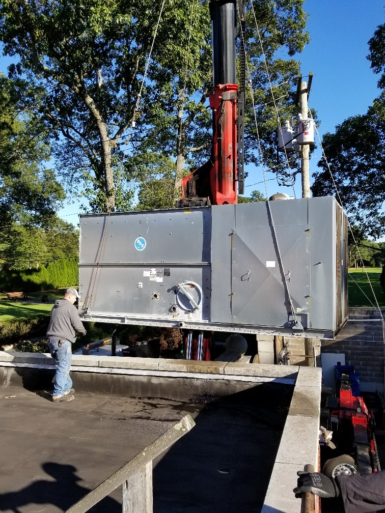 a man pressure washing outside of industrial hvac system