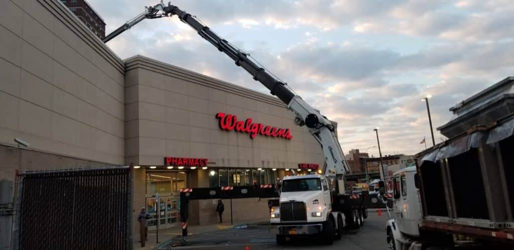 Crane dropping off a new HVAC system on top of Walgreens rooftop