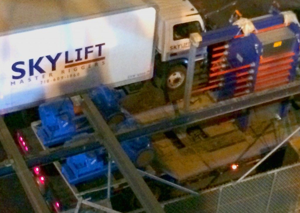 Blue and red cooling tower with blue and red pipes next to Sky Lift cargo truck.