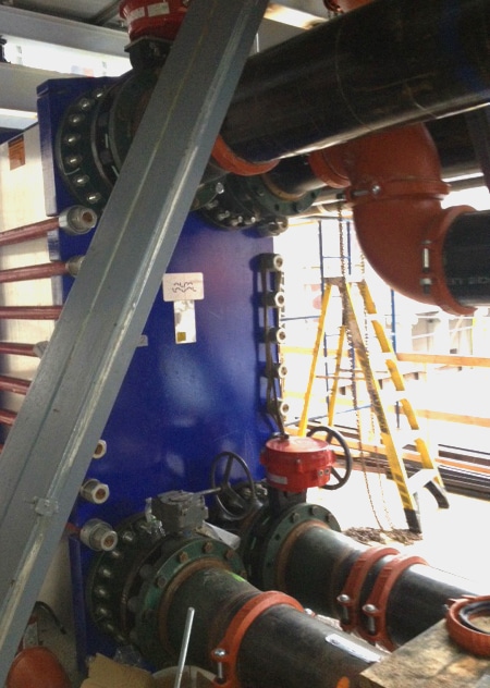 Blue and red cooling tower connected to pipes with valves