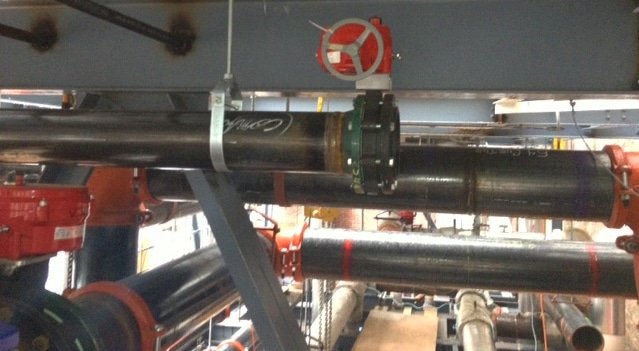Black pipes with red valves connected to HVAC system