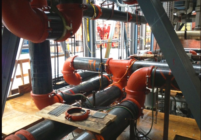 Black and red pipes connected to cooling towers