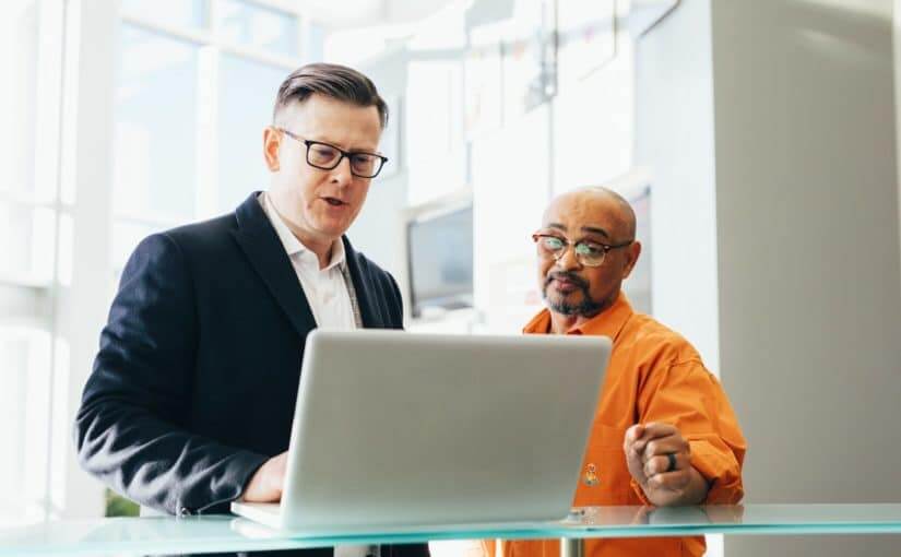 man using silver laptop beside another man 2182973 825x510