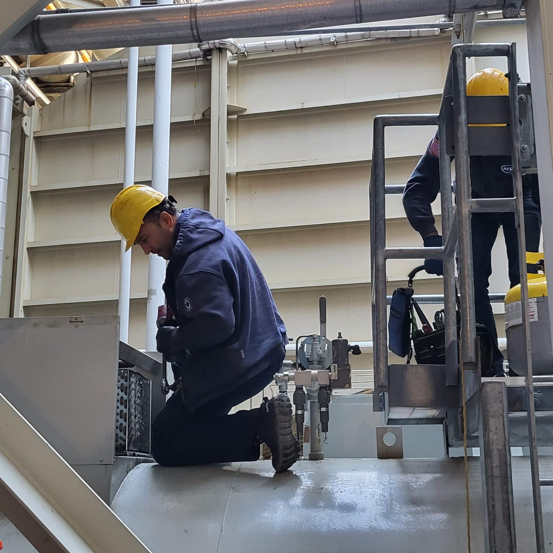 a man pressure washing outside of industrial hvac system